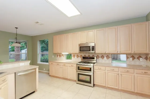 a kitchen with sink a stove and cabinets