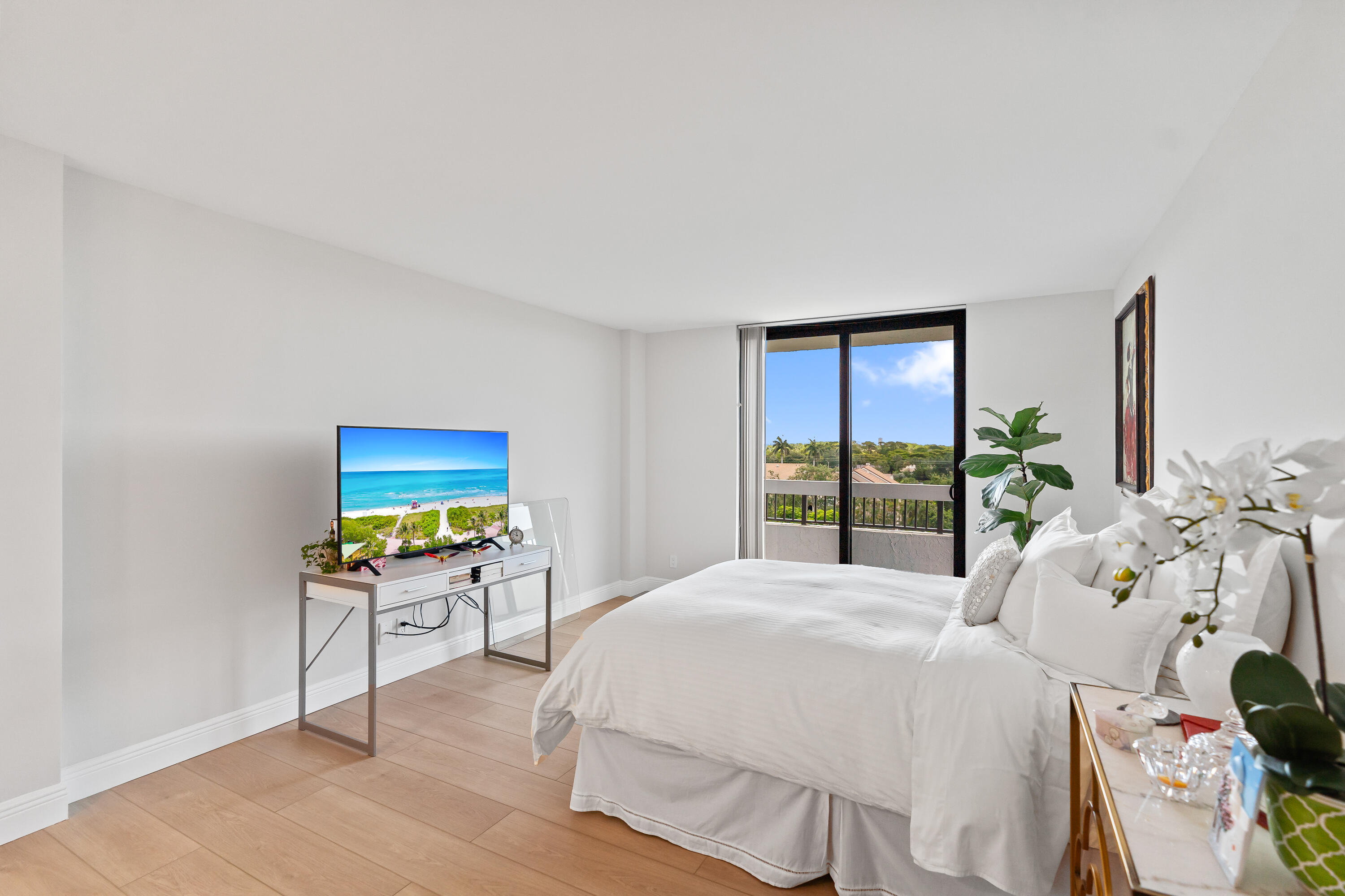 23200 Camino Del Mar, Unit 603 Boca Raton, FL 33433 - Photo 17 of 43 a bedroom with a bed a flat screen tv and a large window