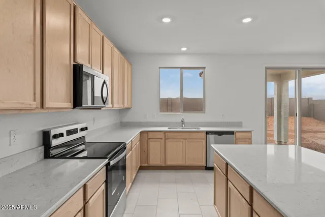 a kitchen with stainless steel appliances granite countertop a sink stove and cabinets