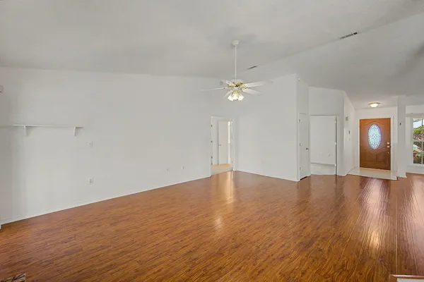 a view of an empty room with wooden floor