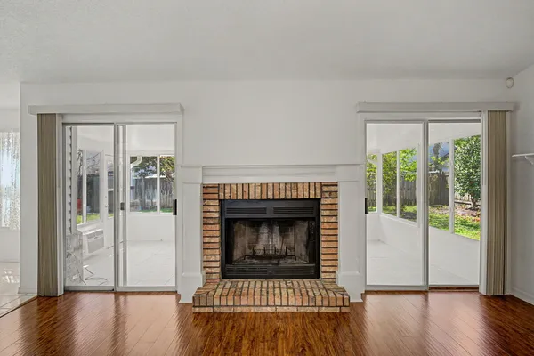 a living room with a fireplace and wooden floor