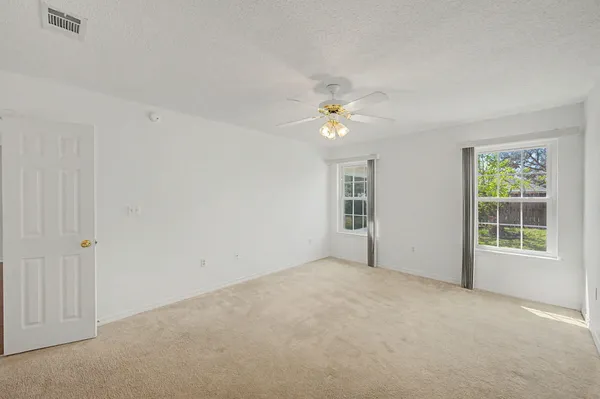 an empty room with windows and closet