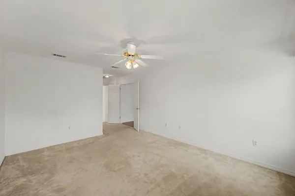 an empty room with a chandelier fan