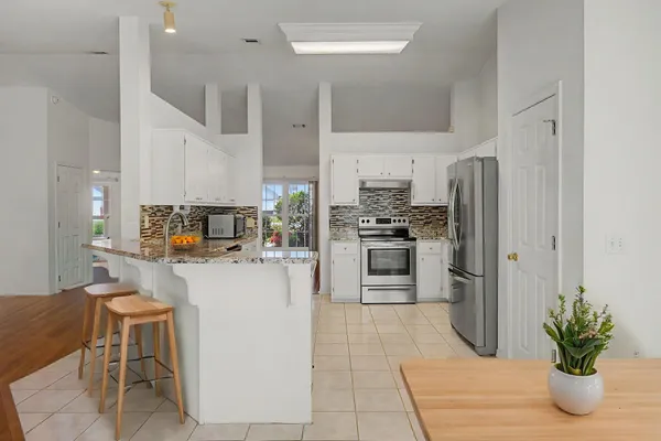 a kitchen with a refrigerator and a stove top oven