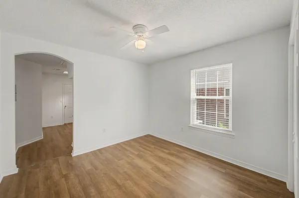 an empty room with wooden floor and windows