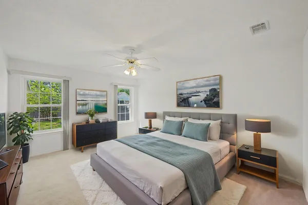 a bedroom with a large bed and a potted plant