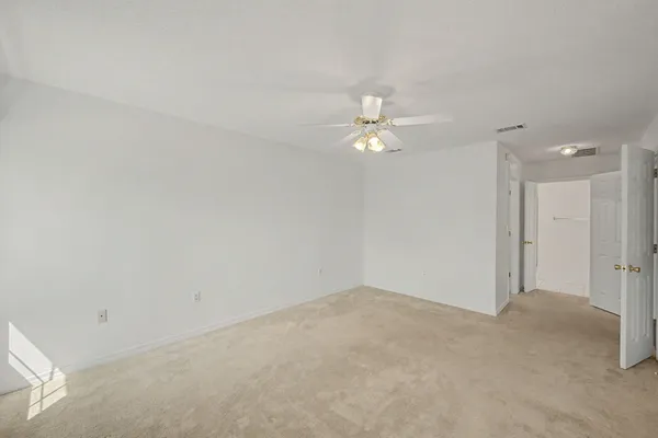 a view of an empty room with a chandelier fan