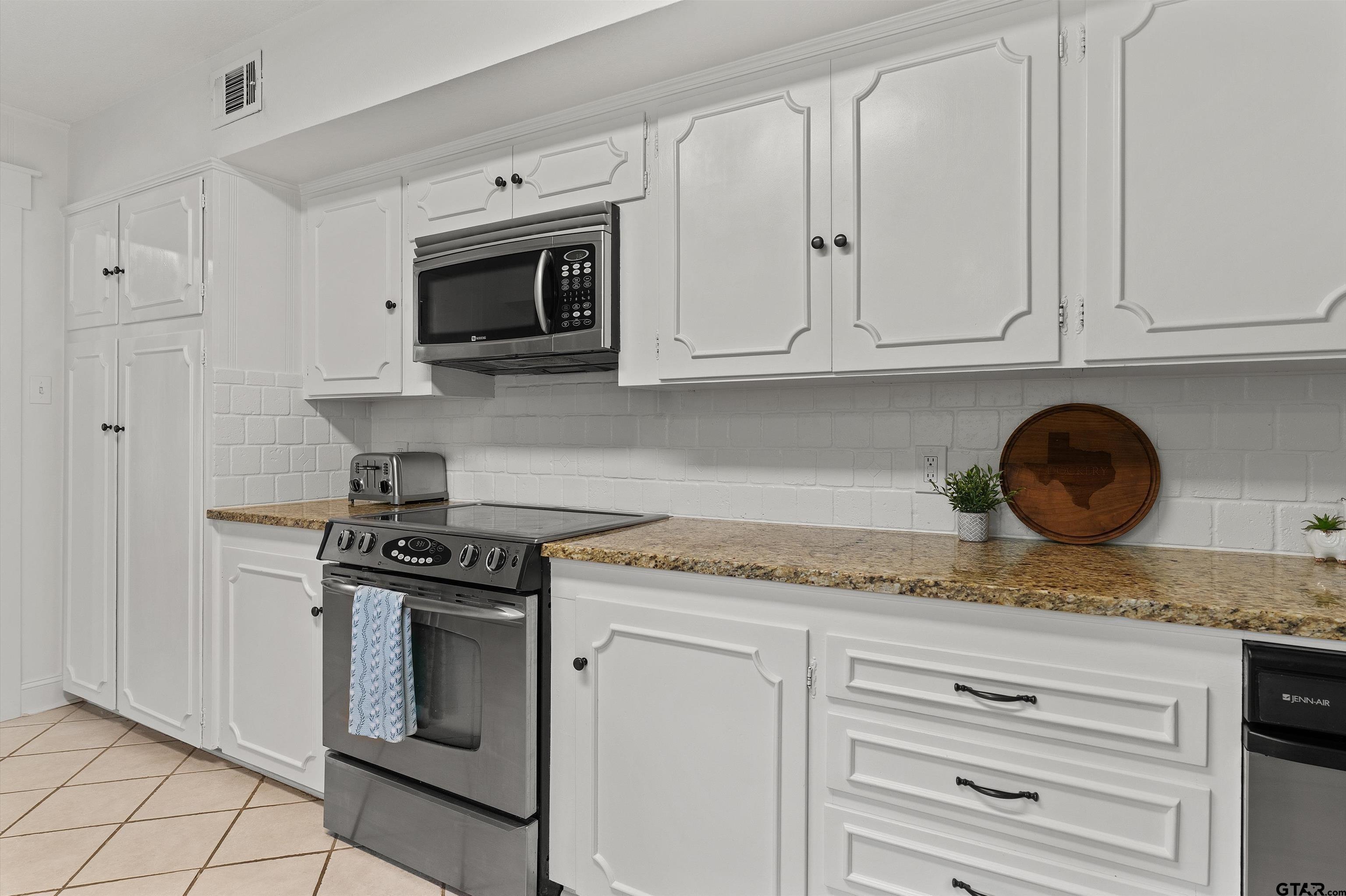 16 Pegues Place Longview, TX 75601 - Photo 19 of 45 a kitchen with granite countertop white cabinets and stainless steel appliances