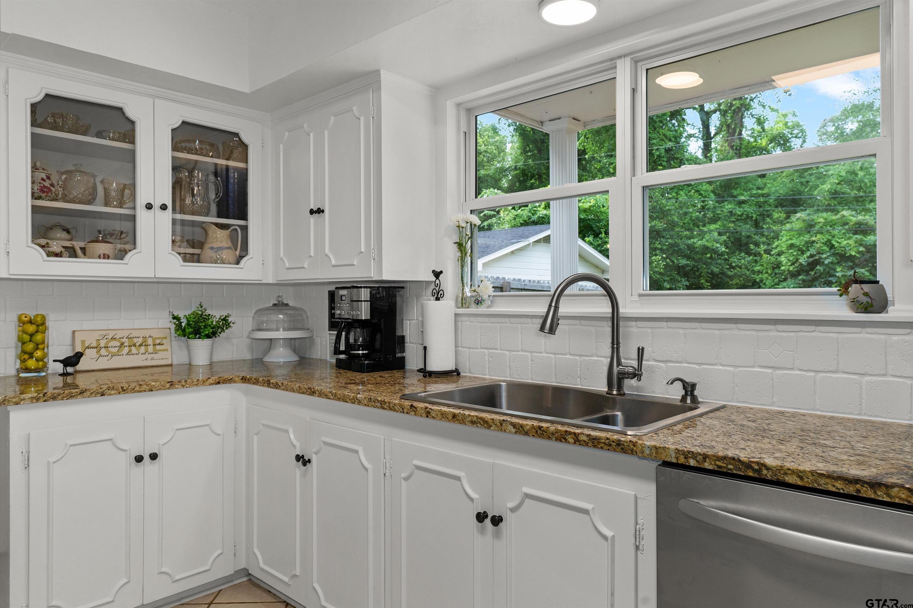 16 Pegues Place Longview, TX 75601 - Photo 20 of 45 a kitchen with stainless steel appliances granite countertop white cabinets and a window