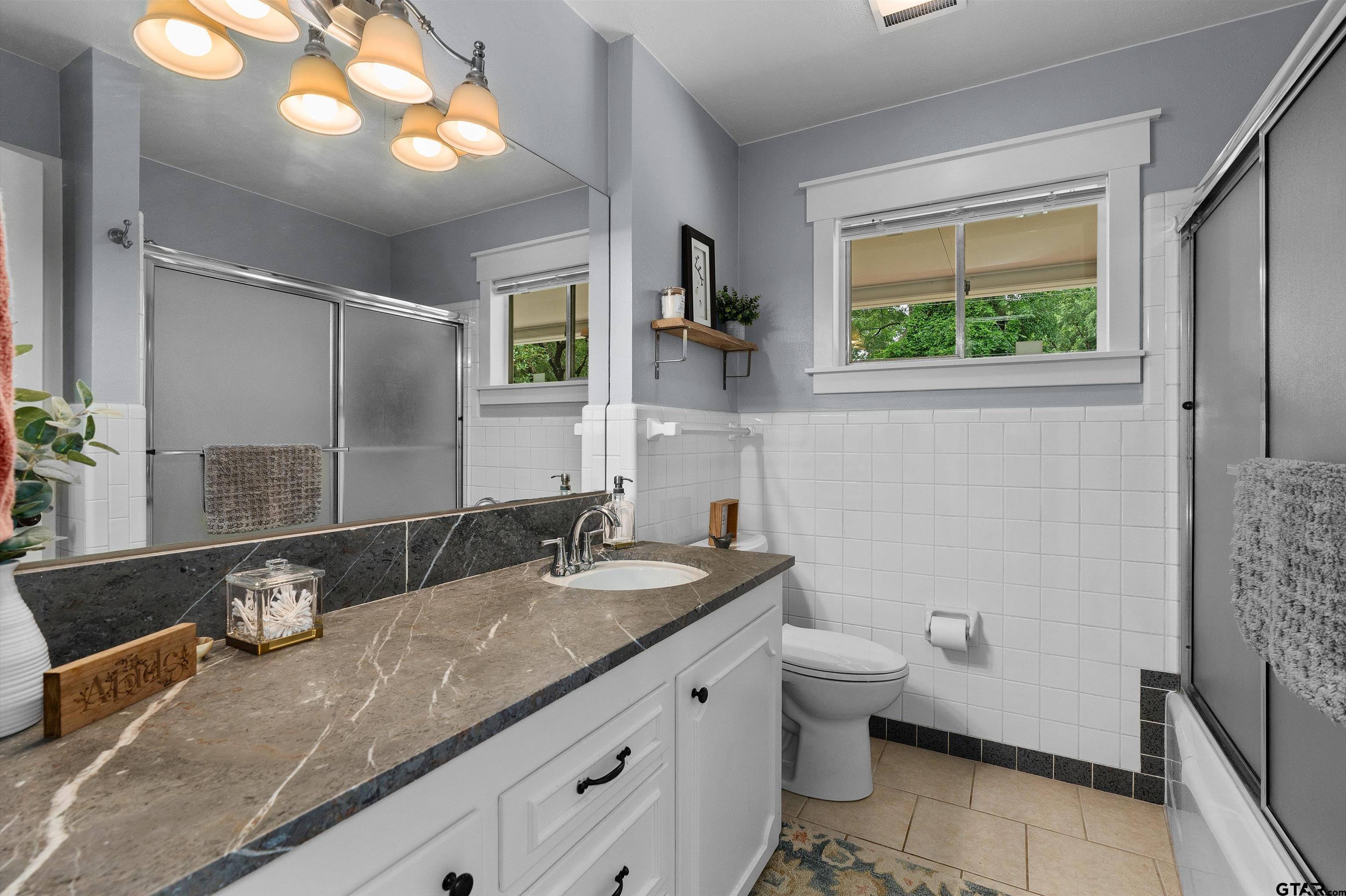 16 Pegues Place Longview, TX 75601 - Photo 31 of 45 a bathroom with a granite countertop sink toilet and mirror