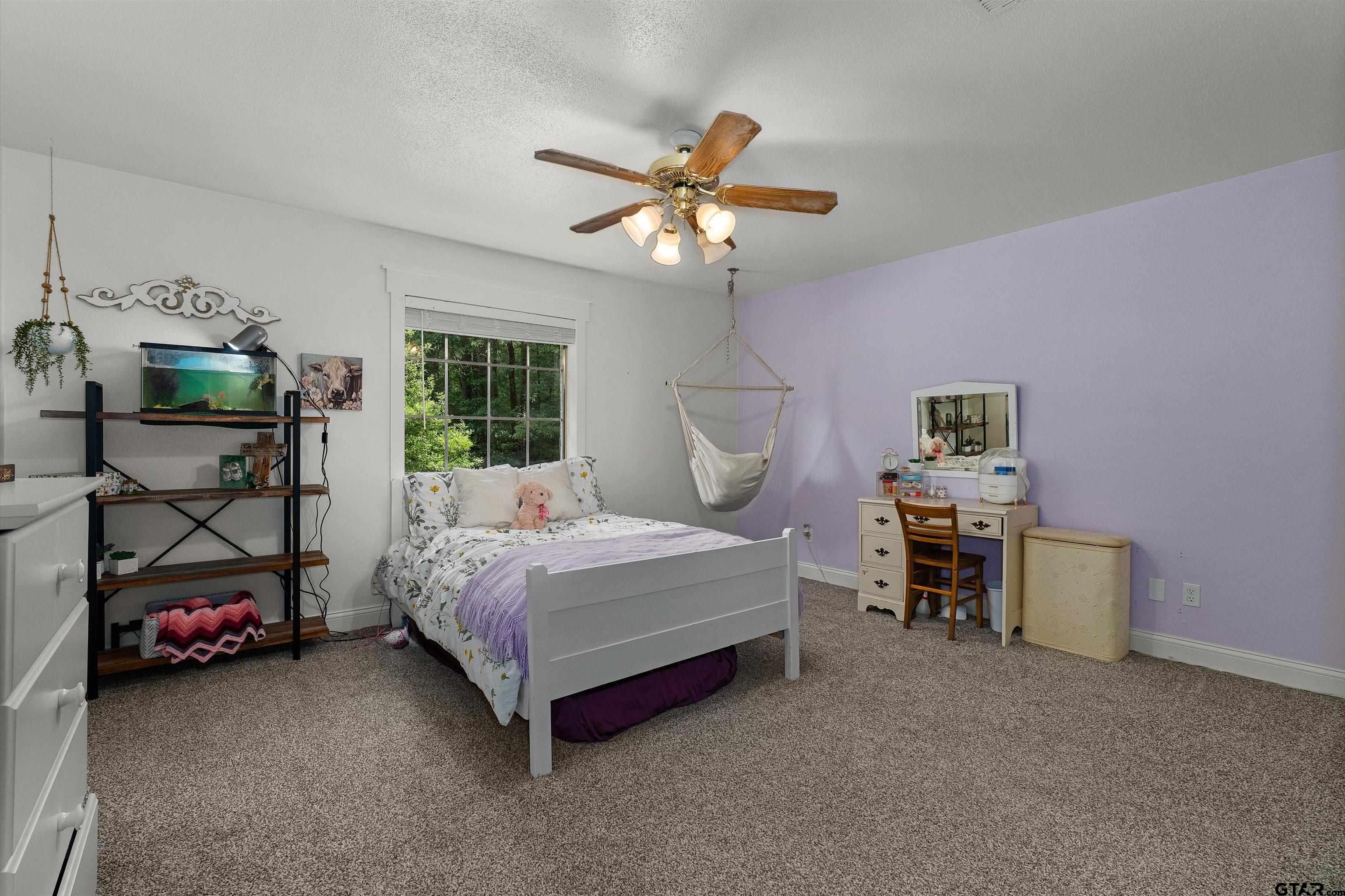 16 Pegues Place Longview, TX 75601 - Photo 32 of 45 a bedroom with a bed and a chandelier