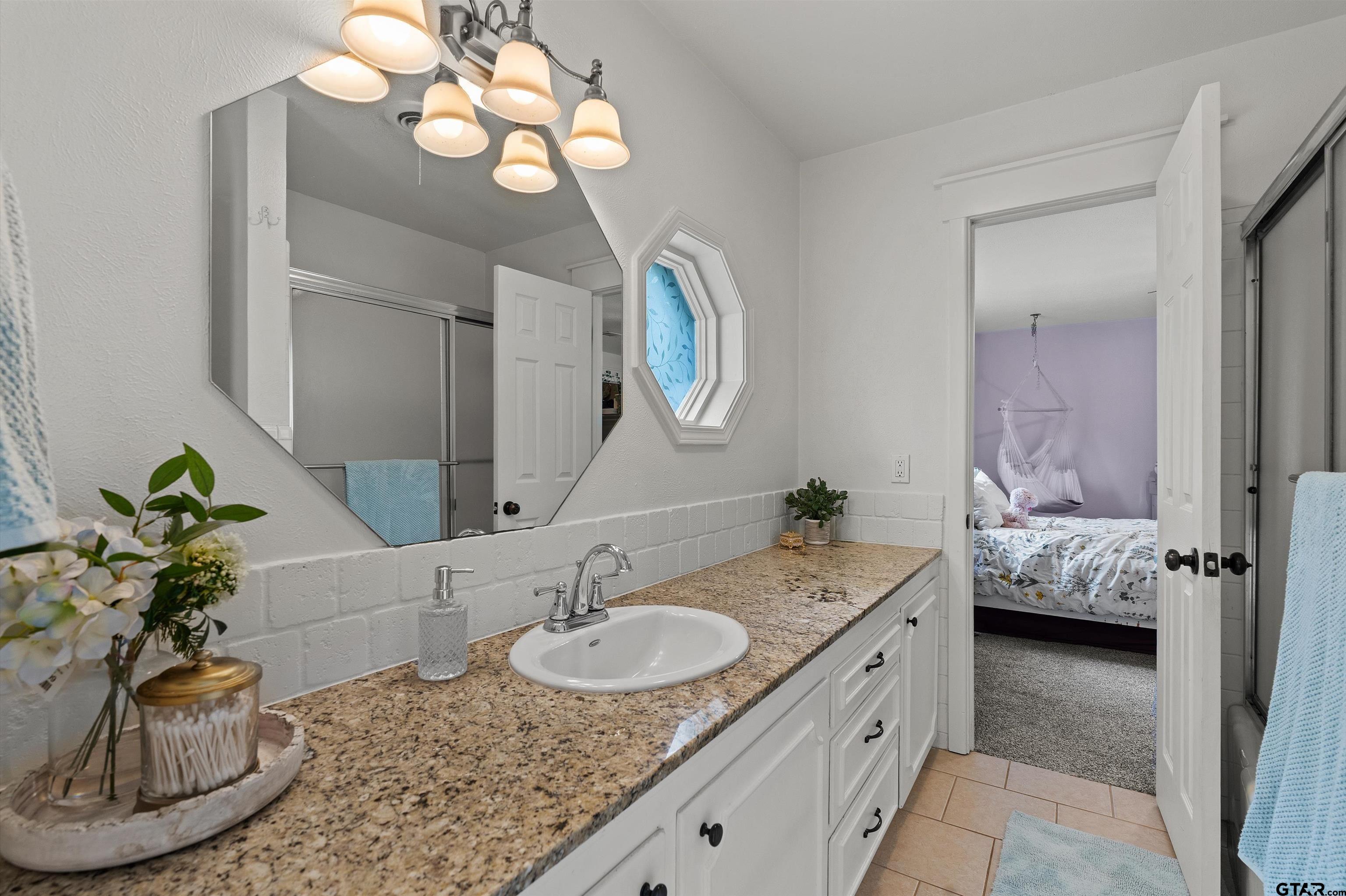 16 Pegues Place Longview, TX 75601 - Photo 34 of 45 a bathroom with a granite countertop sink and a mirror
