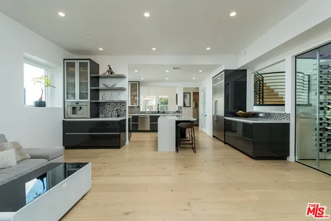 a kitchen with stainless steel appliances kitchen island granite countertop a refrigerator and a sink