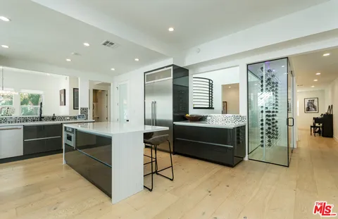 a kitchen with stainless steel appliances kitchen island granite countertop a refrigerator and stove