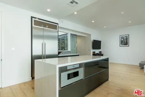 a kitchen with stainless steel appliances granite countertop a sink and a refrigerator