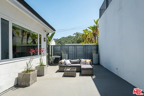 a building outdoor space with patio furniture and potted plants