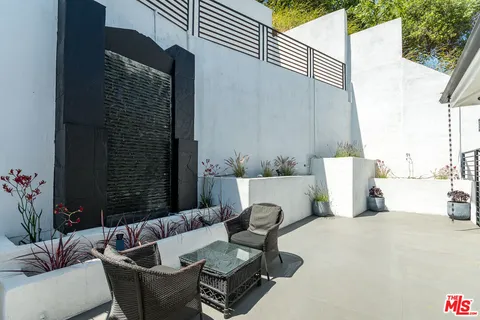 a view of a patio with couches table and chairs and potted plants