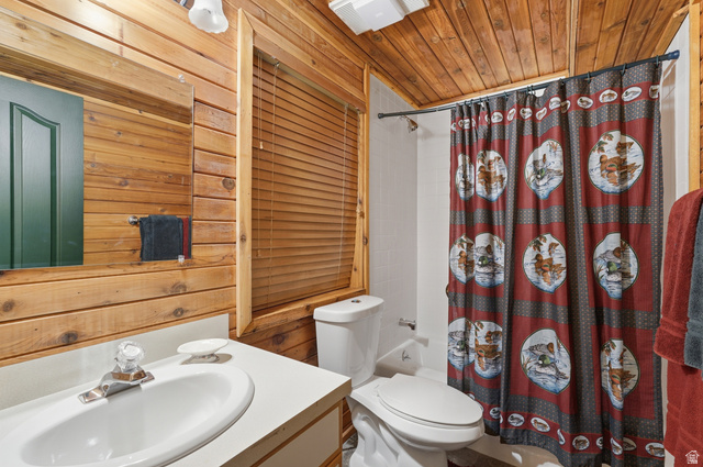 6 Beaver Springs Rancheros Oakley, UT 84055 - Photo 37 of 68 Bathroom featuring wood-paneled walls and ceiling, a white vanity with an integrated sink, a toilet, and a shower with a white tiled surround