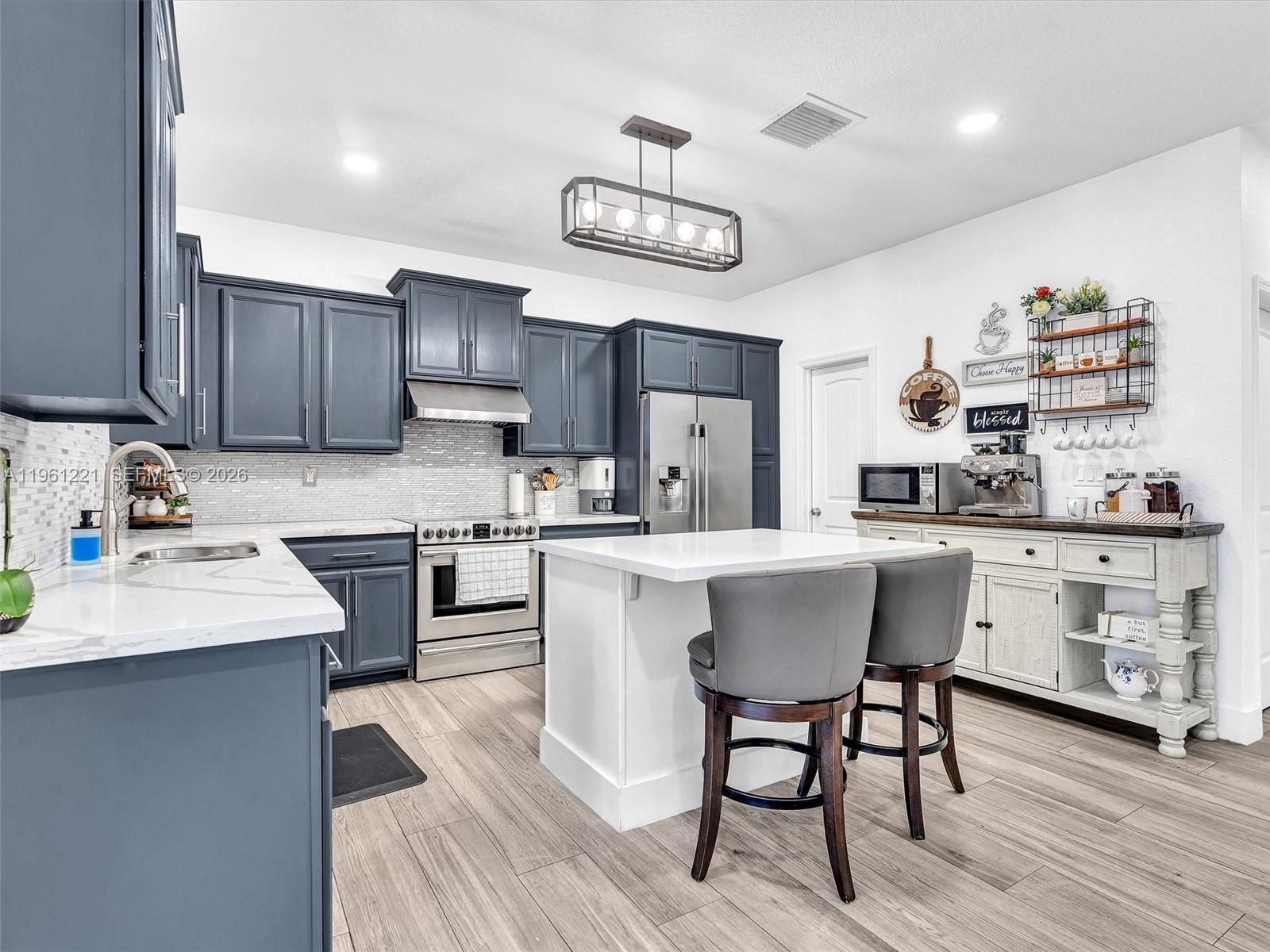 22690 Southwest 127th Court Miami, FL 33170 - Photo 18 of 52 a kitchen with a table chairs stove and cabinets