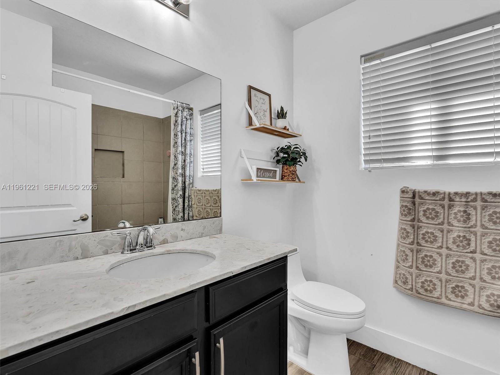 22690 Southwest 127th Court Miami, FL 33170 - Photo 33 of 52 a bathroom with a sink a toilet and a mirror