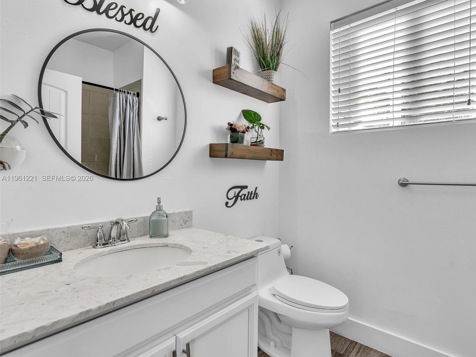 22690 Southwest 127th Court Miami, FL 33170 - Photo 35 of 52 a bathroom with a granite countertop toilet a sink and a mirror