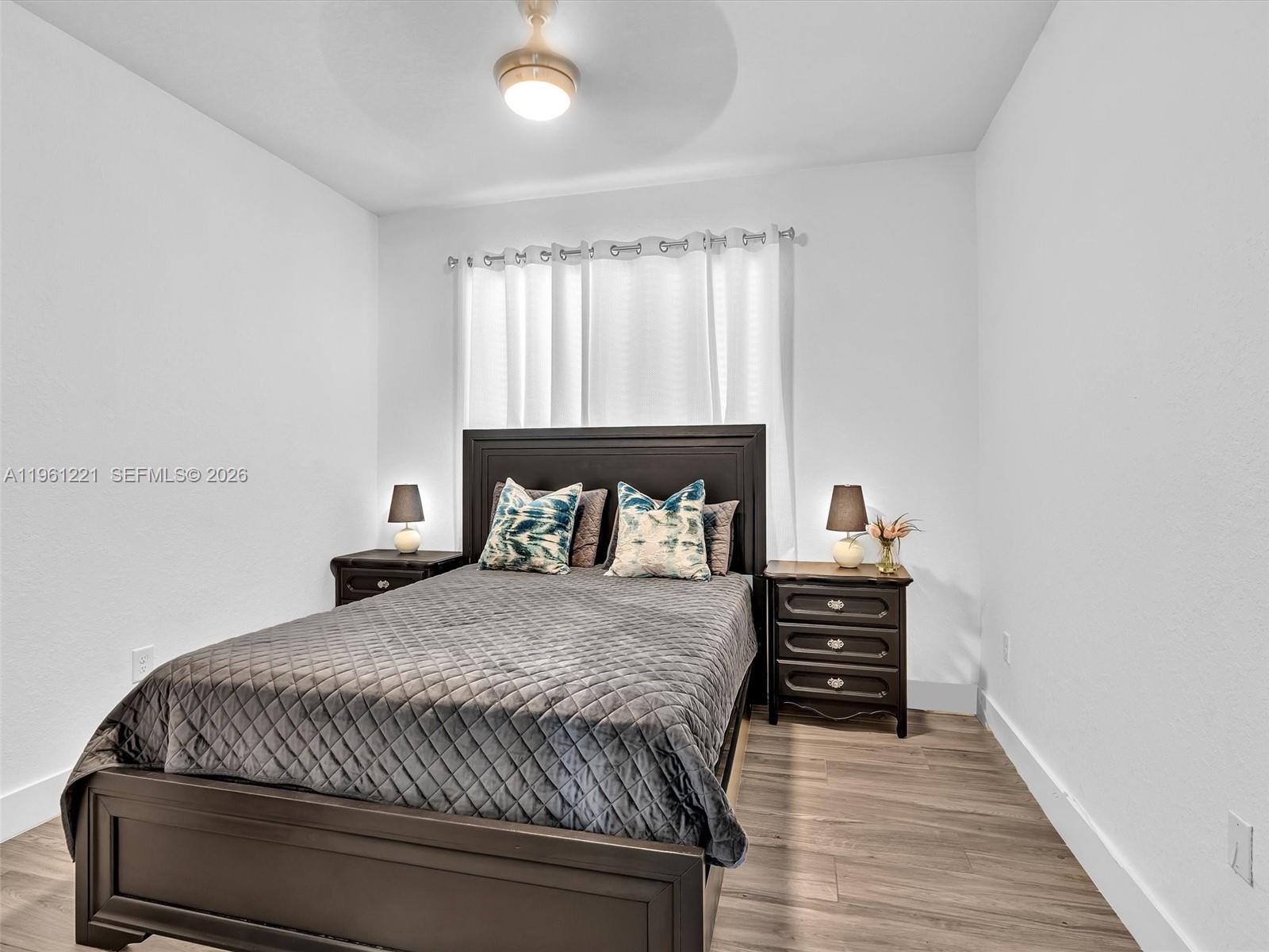 22690 Southwest 127th Court Miami, FL 33170 - Photo 36 of 52 a bedroom with a bed a window and wooden floor
