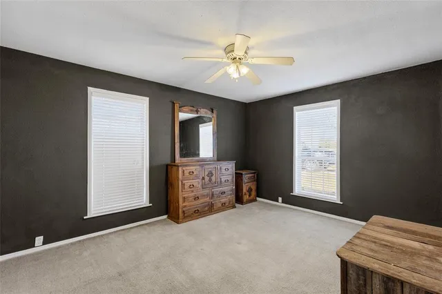 a furnished livingroom with a ceiling fan