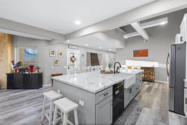 a kitchen with stainless steel appliances granite countertop a refrigerator sink and wooden cabinets