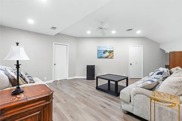 a living room with furniture and a wooden floor