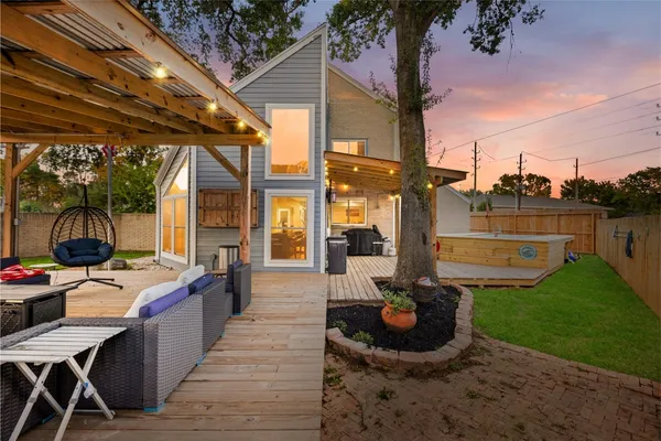 a view of a patio with table and chairs potted plants with wooden floor and fence