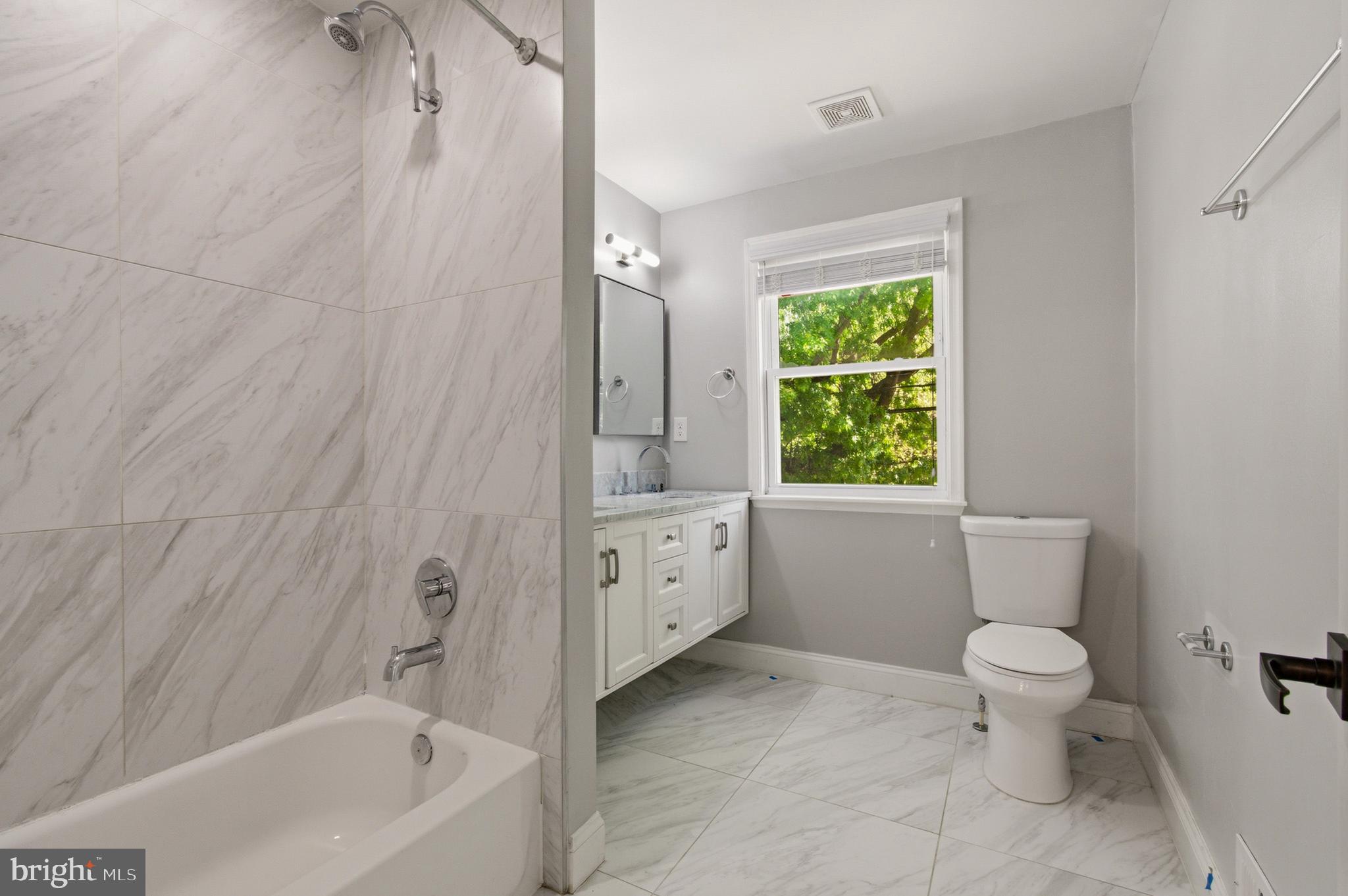 1527 Morris Road Southeast Washington, DC 20020 - Photo 19 of 22 a bathroom with a granite countertop toilet a sink and a bathtub