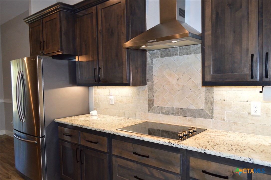 1026 County Road 3152 Kempner, TX 76539 - Photo 11 of 48 a kitchen with granite countertop a refrigerator and a stove