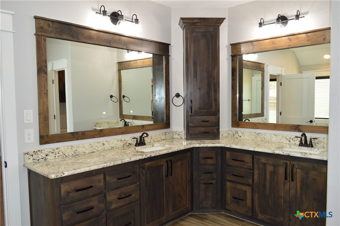 1026 County Road 3152 Kempner, TX 76539 - Photo 18 of 48 The master bath has granite countertops with two individual sink areas, framed mirrors, lots of storage, soaker tub, separate shower, and private water closet.