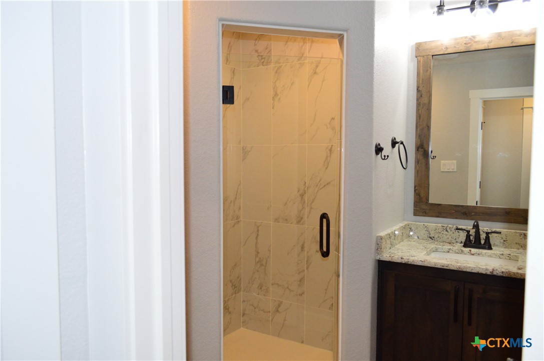 1026 County Road 3152 Kempner, TX 76539 - Photo 26 of 48 a bathroom with a granite countertop sink and shower