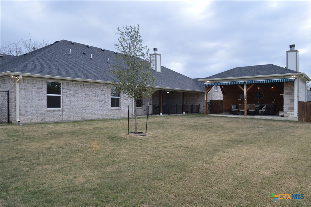 1026 County Road 3152 Kempner, TX 76539 - Photo 33 of 48 Back of Home ~ Attached 34' Covered Patio * Flat Back Yard * 24' X13' Back Yard Entertainment Area with Over-Sized Fireplace, Cabinets and Outdoor Refrigerator, Electric Awning
