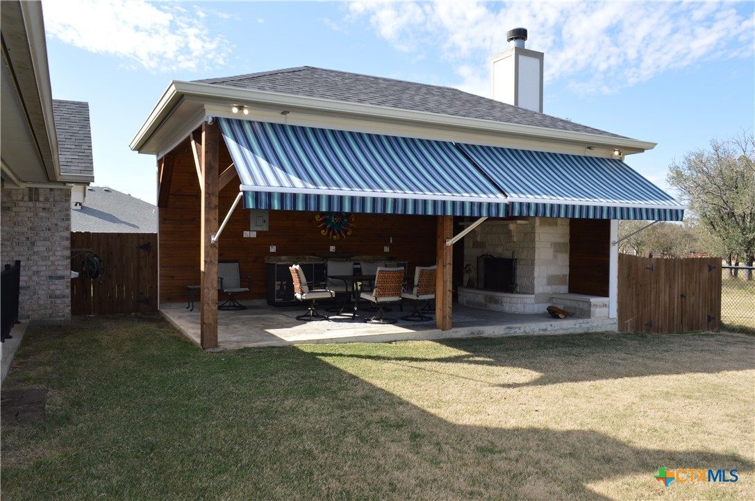 1026 County Road 3152 Kempner, TX 76539 - Photo 37 of 48 Custom One-of-a-Kind Outdoor Entertainment Area with Cabinets with Granite Countertop, Pendant Lighting, Ceiling Fan, Electric Awning, and Over-Sized Fireplace with Raised Hearth