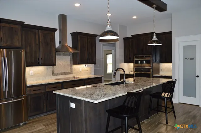 a view of a livingroom with a fireplace wooden floor and windows