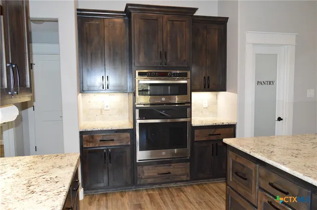 a kitchen with granite countertop a stove and a refrigerator