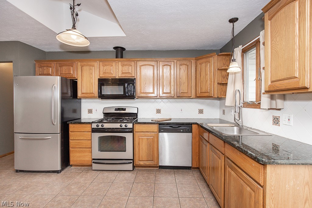 7484 Oberlin Road Elyria, OH 44035 - Photo 6 of 27 Kitchen featuring hanging light fixtures, stainless steel appliances, light tile flooring, and sink