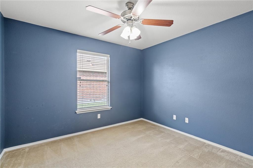 20224 Merlin Falcon Trail Pflugerville, TX 78660 - Photo 32 of 40 A window-filled bedroom with a ceiling fan for year-round comfort.