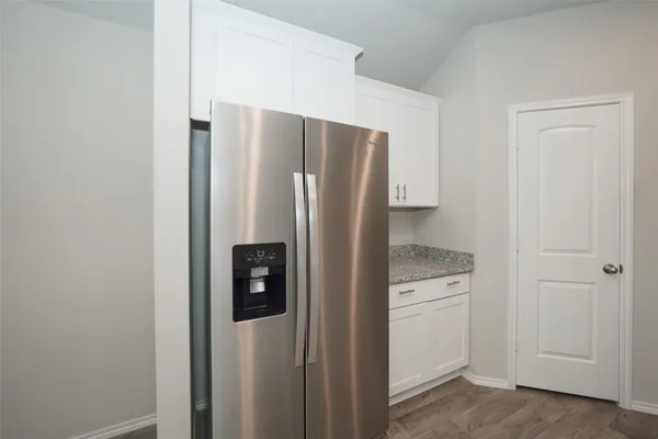 a metallic refrigerator freezer sitting in a kitchen