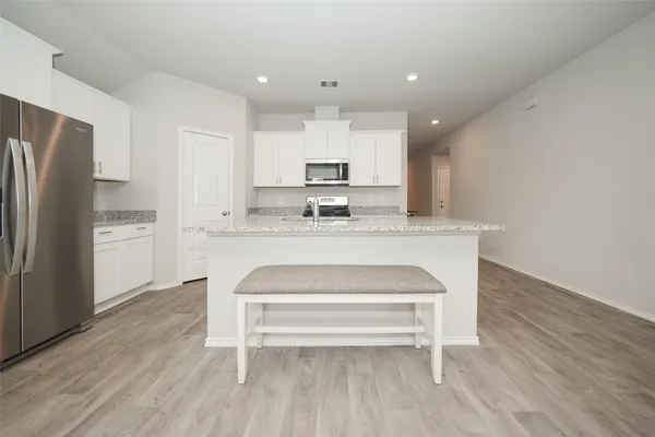 a view of kitchen with wooden floor and refrigerator