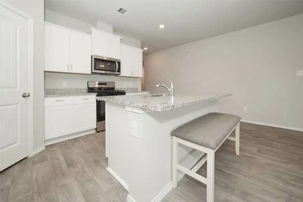 a kitchen with stainless steel appliances granite countertop a microwave sink and refrigerator