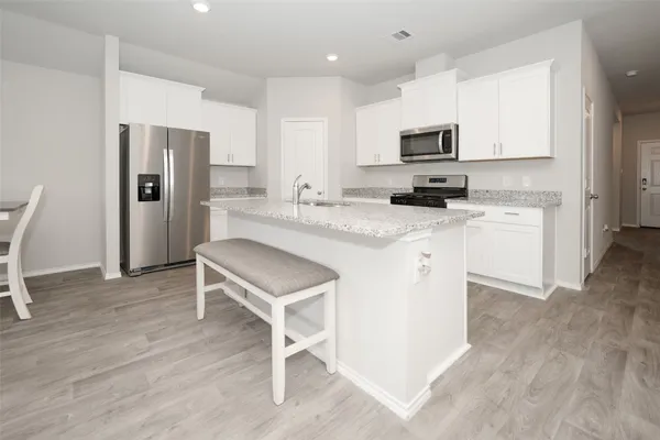 a kitchen with a sink a microwave a refrigerator and cabinets