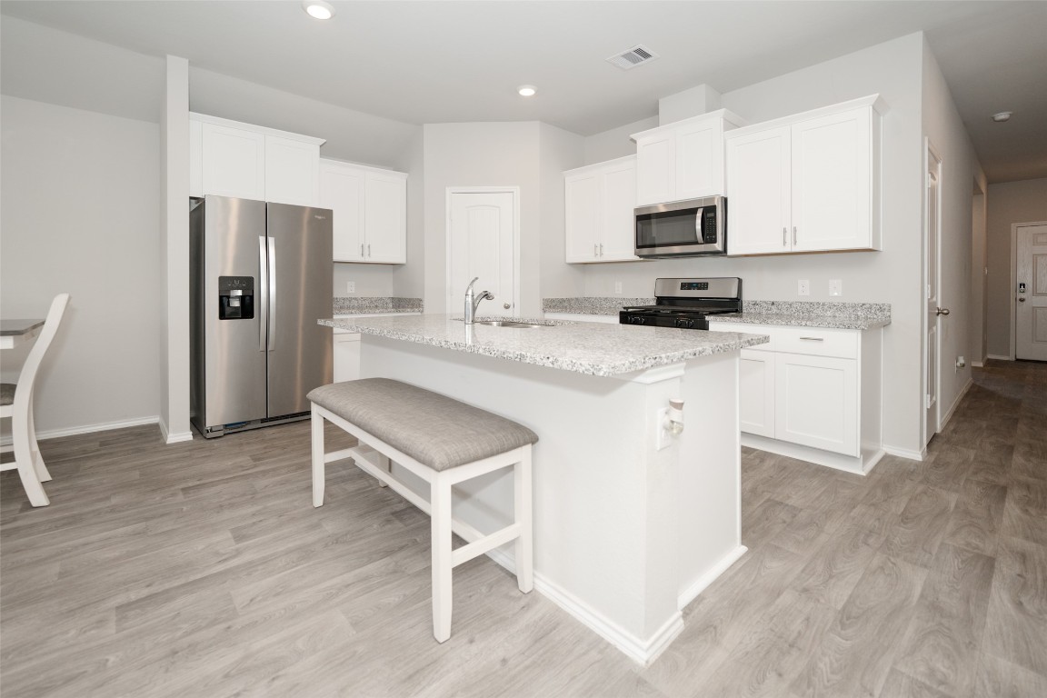 2407 Divot Lane Navasota, TX 77868 - Photo 17 of 37 a kitchen with a sink a microwave a refrigerator and cabinets