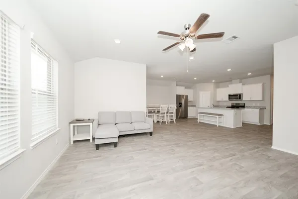 a living room with furniture and kitchen view