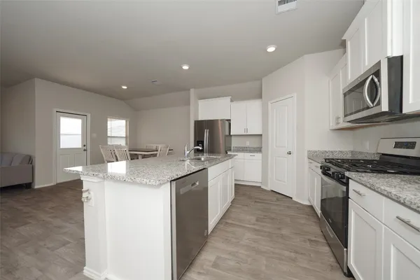 a kitchen with stainless steel appliances granite countertop a sink and stove top oven