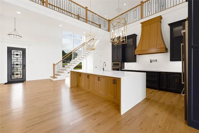 a large kitchen with stainless steel appliances kitchen island granite countertop a large cabinets a sink and wooden floor