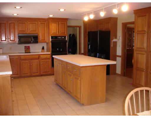 82 Whiley Road Groton, MA 01450 - Photo 13 of 30 a kitchen with stainless steel appliances kitchen island granite countertop a refrigerator a stove top oven and sink