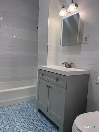 a bathroom with a sink a toilet and bathtub